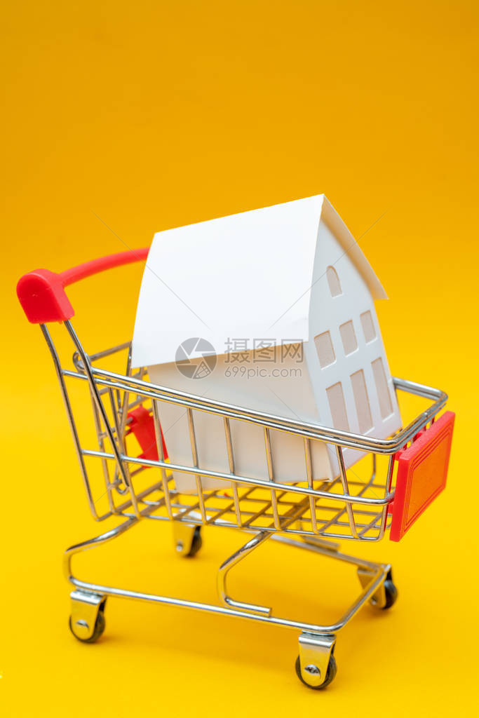 黄色玩具购物车白色小型房屋模型的近视镜头图片