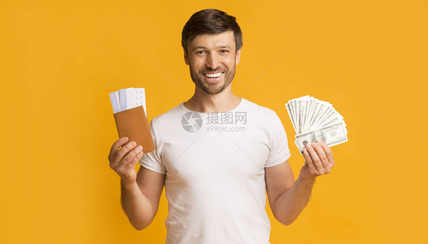 金钱和护照在镜头中微笑站在黄色背景上图片