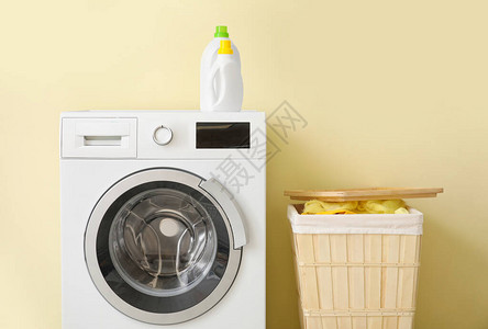洗衣机和篮子靠近彩墙背景图片