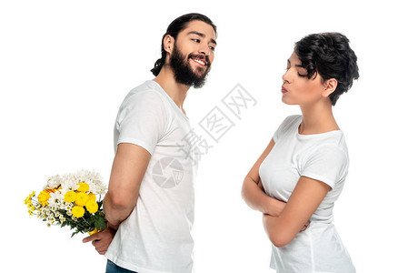 快乐的拉丁男人拿着黄色花朵在女人身边站着手持十字臂图片