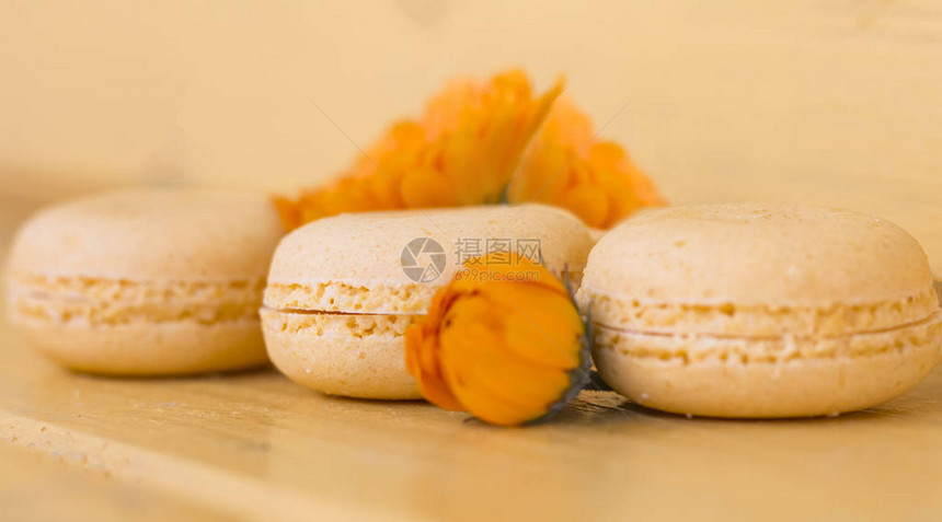 黄背景的3个精细黄色红杏仁蛋糕图片