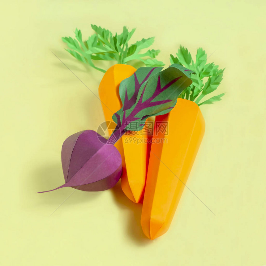 五颜六色的体积胡萝卜和甜菜由黄色背景上的纸制成纸艺和工艺时髦的爱好创意素食健康或图片