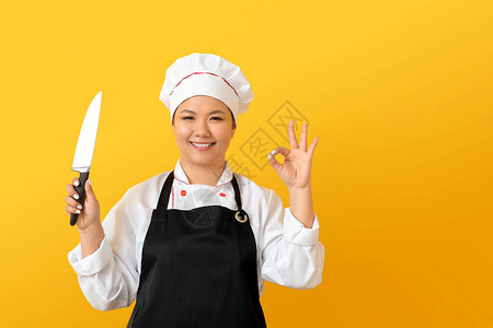 美丽的亚洲厨师刀子在彩色背景图片