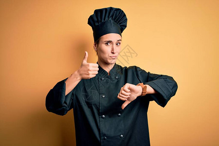 身着厨师制服和帽子站在黄色背景的年轻女厨师图片