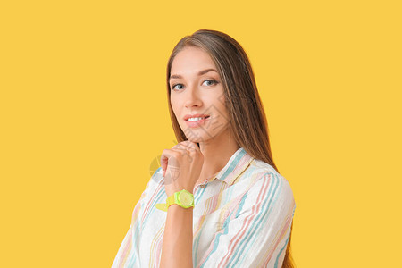 彩色背景上带手表的年轻女子图片