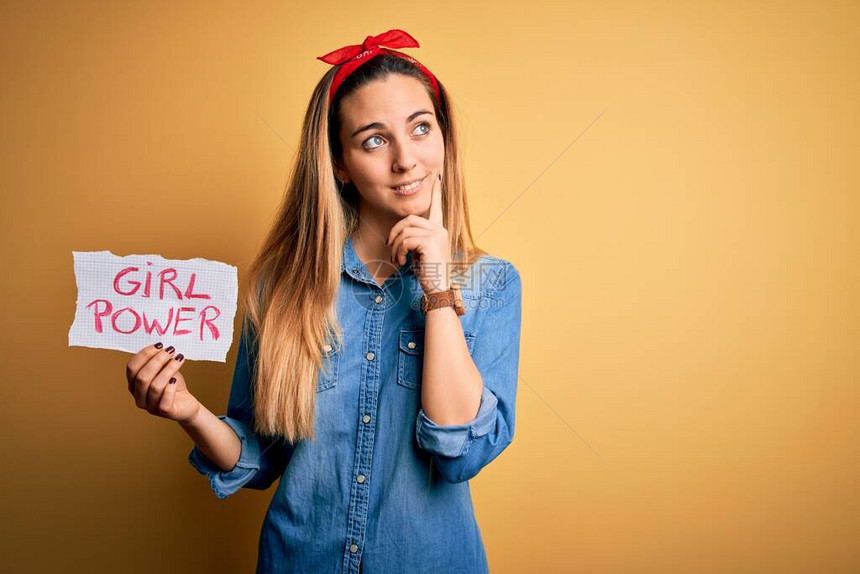 蓝眼睛的金发女人要求女孩举着横幅挂有女孩力量信息严肃地面对问题图片