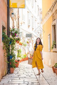穿黄色防晒衣的女游客在小克罗泰亚城背景图片