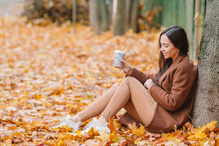 在秋天公园喝咖啡的快乐女人秋天图片