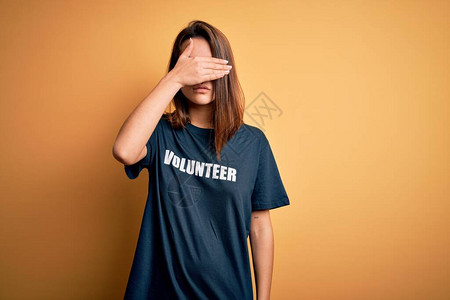 年轻美丽的黑发女孩穿着短袖圆领汗衫从事志愿工作图片