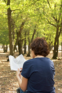 在秋天的森林里看书的女人图片