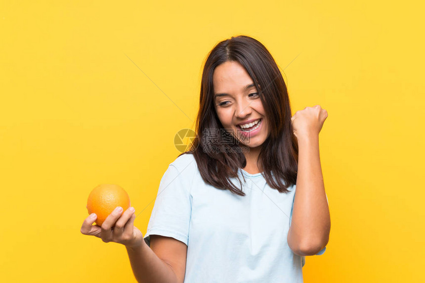 年轻的黑发女人拿着橙子庆图片