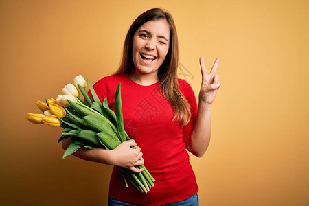 年轻的金发女人拿着一束浪漫的郁金香花图片