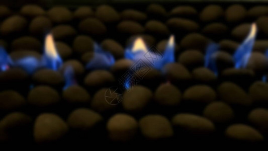 蓝气火在壁炉地板上通过小石块咆背景图片