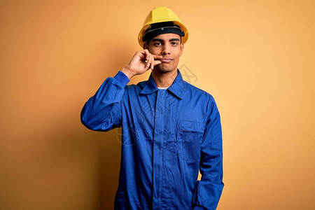 年轻英俊的非洲裔美国工人身穿蓝色制服图片