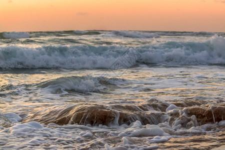 海浪在黎明时分冲浪图片