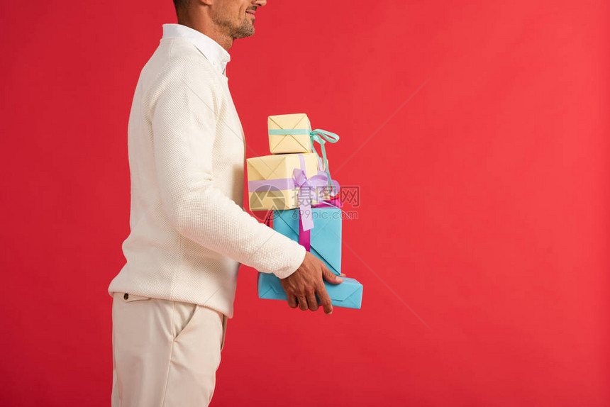 带着礼物盒的笑着男子在红色光天化图片