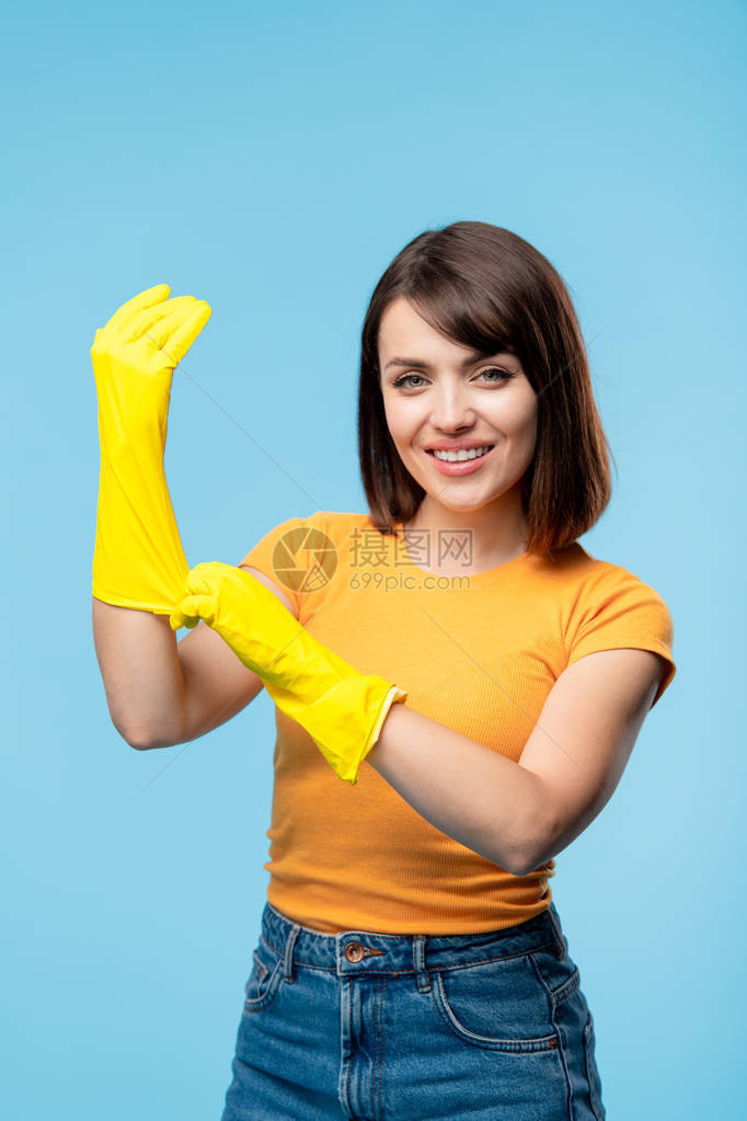 快乐的年轻女管家或清洁服务人员在会议室订购时手拿黄色橡皮手套图片