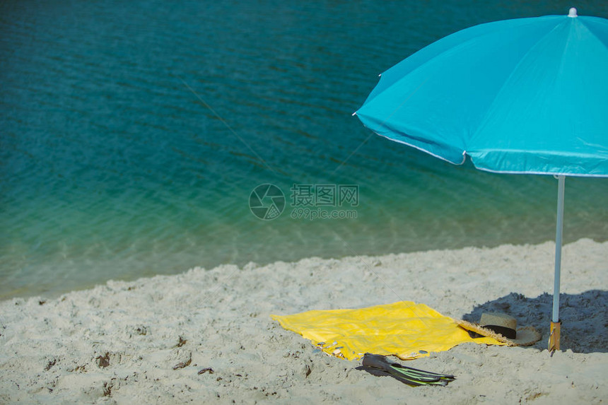 太阳蓝伞和沙滩上黄色毯子的太阳蓝色雨伞风景图片
