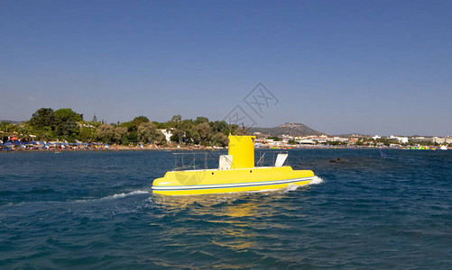 黄色潜水艇沿着旅游海滩在海上航行图片