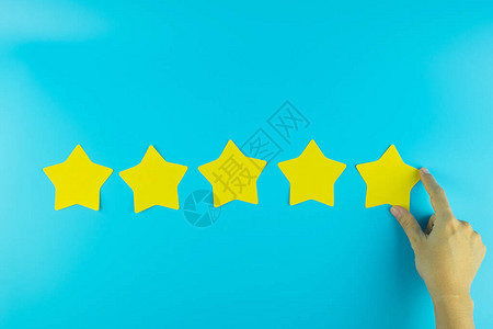 客户在蓝色背景上持有五星级黄色纸条客户评论反馈评级排图片