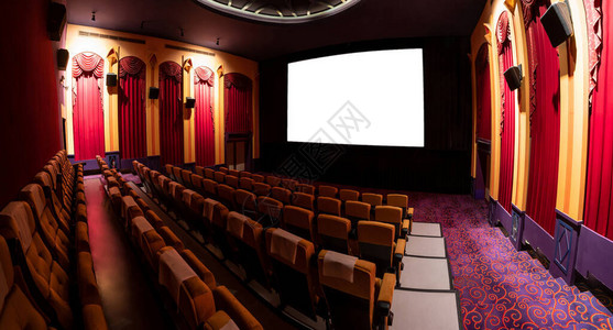 电影院座位排前的电影院屏幕显示从电影放映机投影的白色屏幕图片