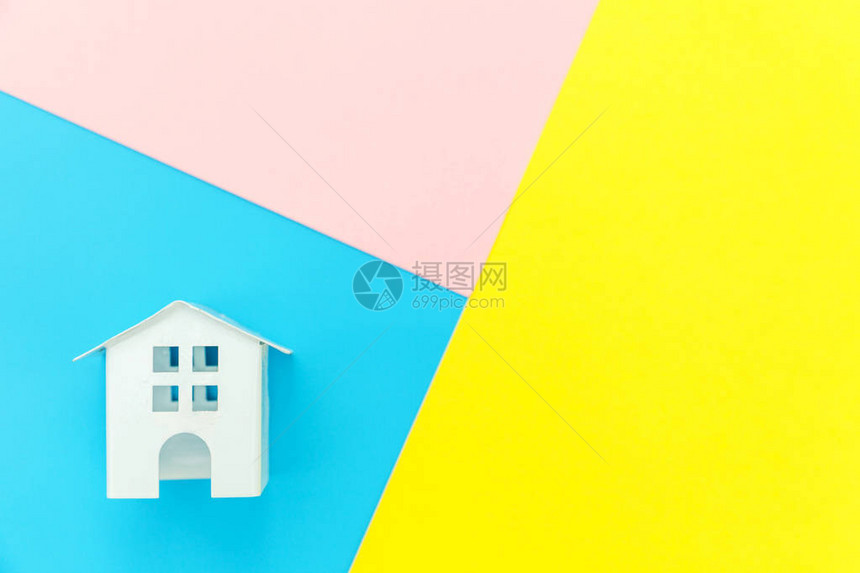 简单地设计与孤立在蓝色黄粉红色柔和多彩时尚几何背景上的微型白色玩具屋抵押财产保险梦想家园概念平躺顶图片