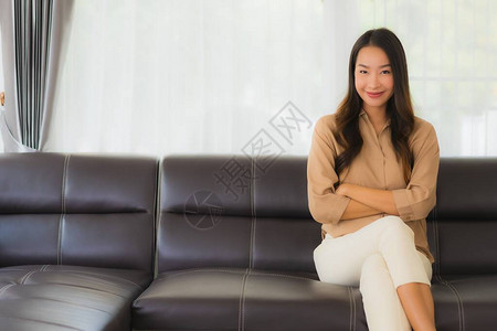 肖像美丽的亚洲年轻女快乐的微笑在客厅内部图片