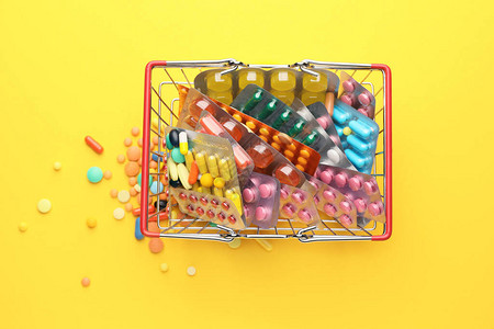 彩色背景上带药丸的小购物篮图片