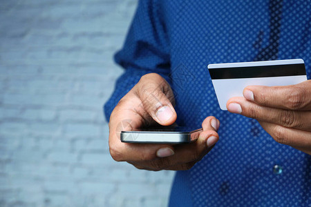 手持信用卡和上网使用智能手机购物的人u图片