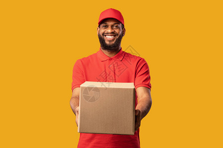 交付服务非裔美国人的保镖提供纸箱摄像头通过黄室背景从在线商店到家笑声图片