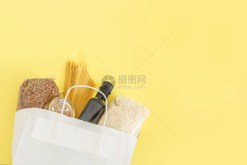 具有必要食品长保质期的纸袋在黄色背景下被隔离在线购物和非接触式交付概念冠状图片