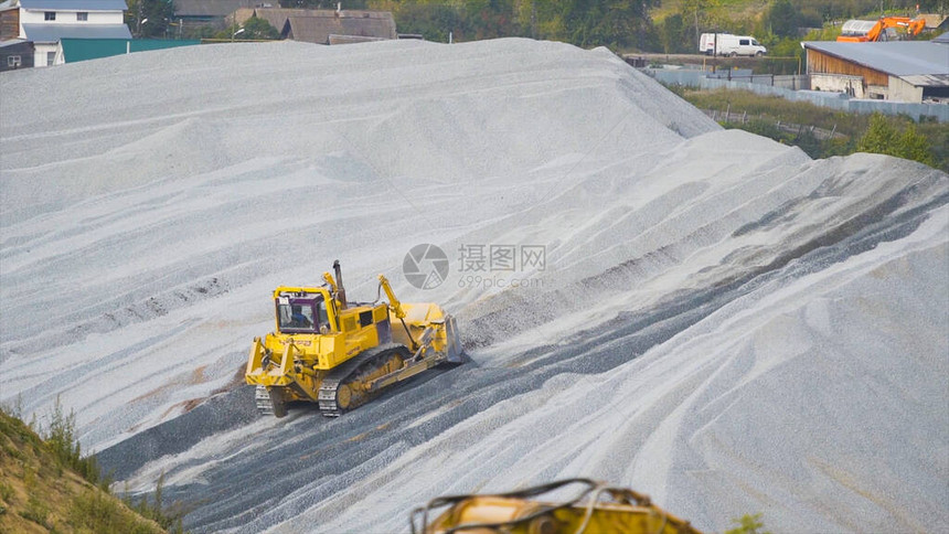 拖拉机清除了瓦砾堆上的道路混凝土采矿或重型运输的建筑工程图片