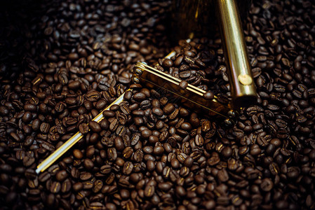 在咖啡店咖啡厅或餐厅的烘焙咖啡豆机中烘焙的咖啡豆图片