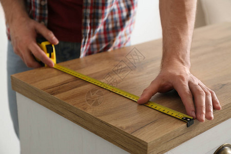 人测量木制壁橱闭图片