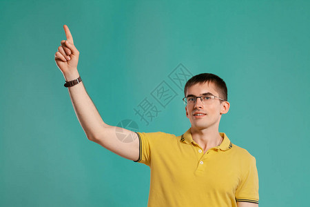 一个穿着黄色休闲T恤眼镜和黑色手表的帅哥在工作室拍摄图片
