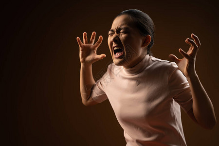 愤怒的亚洲女人展示她的拳头大喊图片
