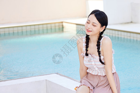 在泳池边玩水的美女图片