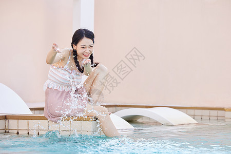 在泳池边玩水的美女背景图片