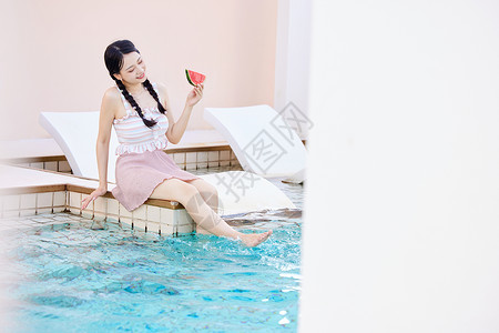 夏天泳衣西瓜手拿西瓜在泳池边玩水的美女背景