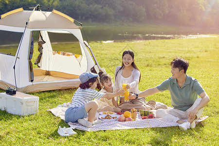 一家人在草地幸福家庭在户外露营野餐背景