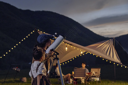 守望星空男孩儿童露营夜晚使用天文望远镜看星空背景