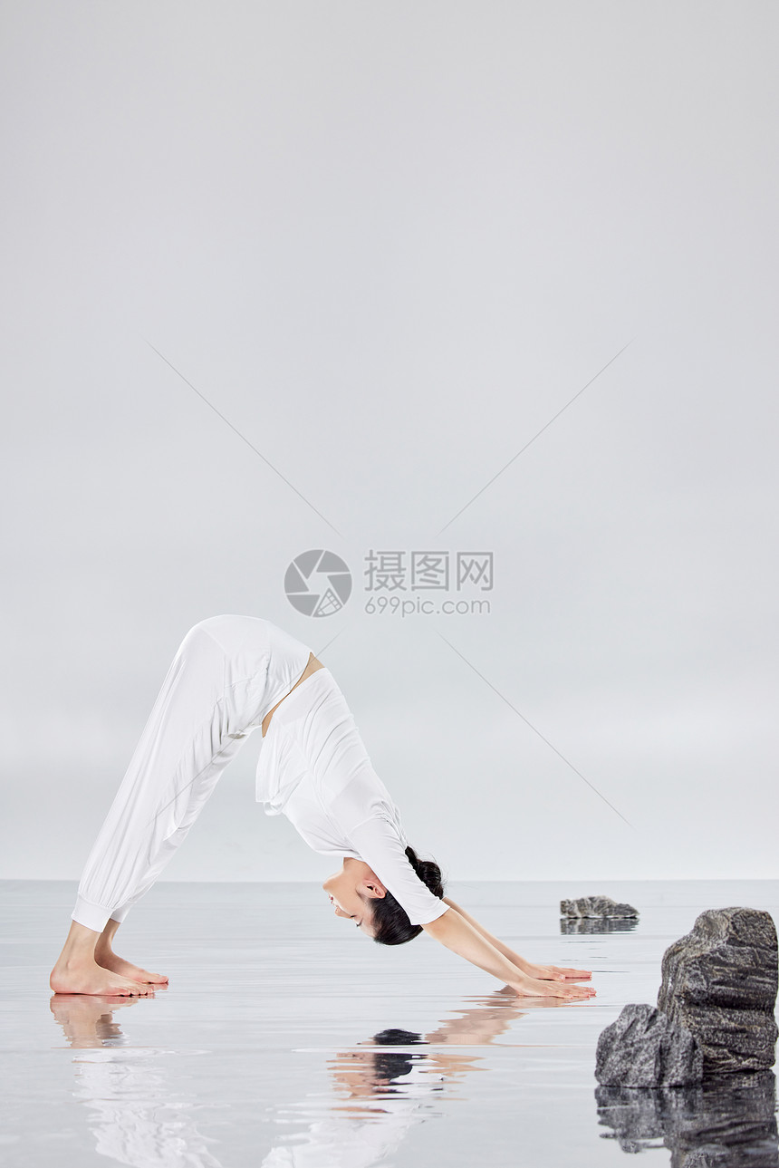 在禅意水面上做瑜伽运动的女青年图片