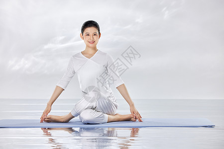 禅意水面上做瑜伽运动的青年女性图片