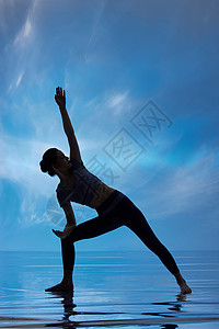 蓝色背景做瑜伽的女性剪影高清图片
