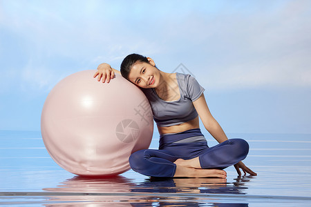 用瑜伽球锻炼身体的女性形象图片