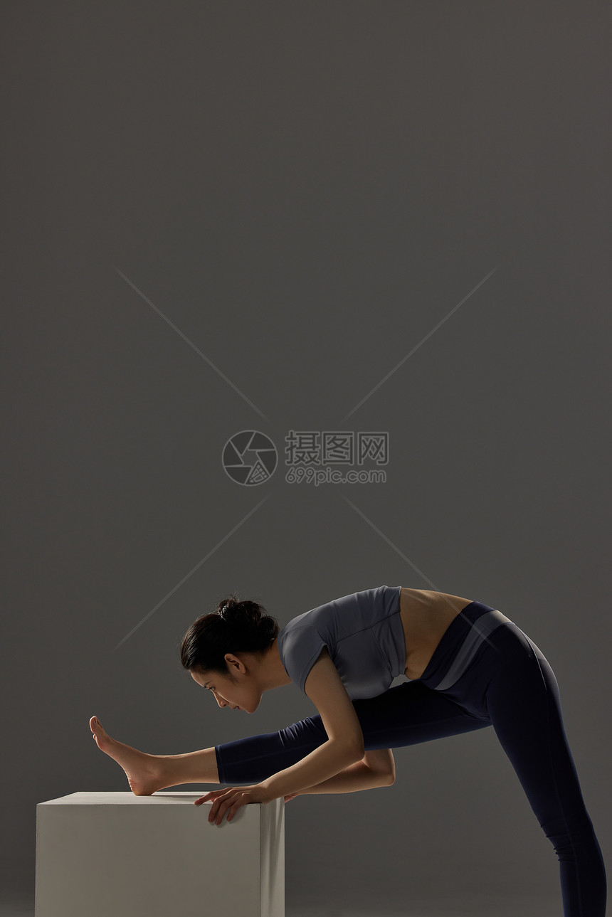 深色背景做瑜伽锻炼的女性图片
