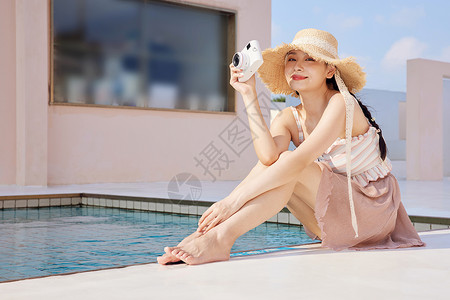 女生泳衣泳池边手拿照相机的美女背景