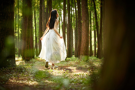树林里奔跑的美女背影图片