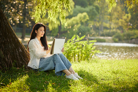 女生画画在公园树下画画的美女背景