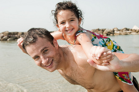父亲在沙滩上背着女儿图片